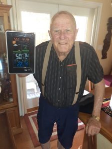 Vince is happy showing the digital weather station to prove his house stays cool when it is hot outside.