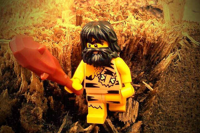 A LEGO minifig caveman standing in a field