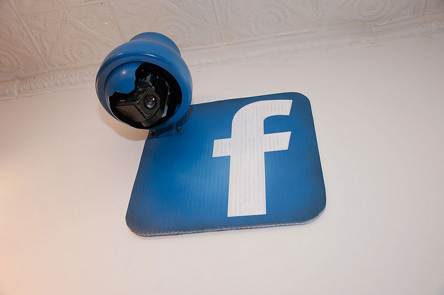 A facebook logo next to a surveillance camera